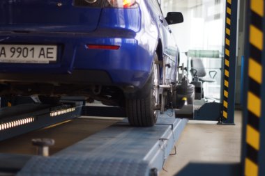 Tekerlekler hizalama kamber için gezici sensörleri ile stand arabayı kontrol servis istasyonu atölyesinde.