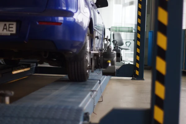 Auto op de stand met sensoren op wielen voor wielen uitlijning camber controleren in de werkplaats van tankstation. — Stockfoto