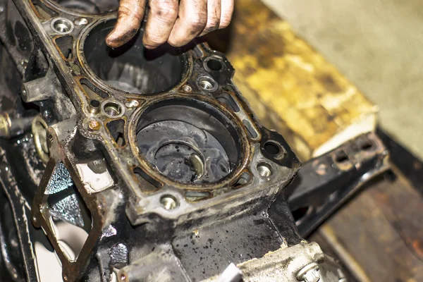 Mecânico trabalhando com o motor em uma oficina — Fotografia de Stock