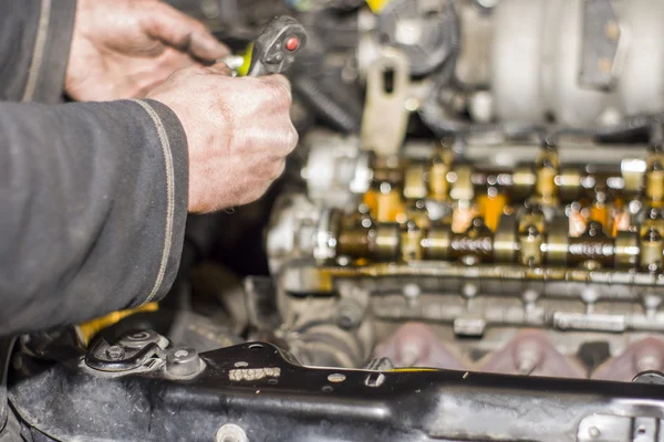 Mechanic werken met met motor in een workshop — Stockfoto