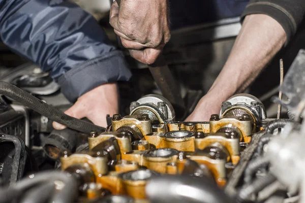 Mechanic werken met met motor in een workshop — Stockfoto