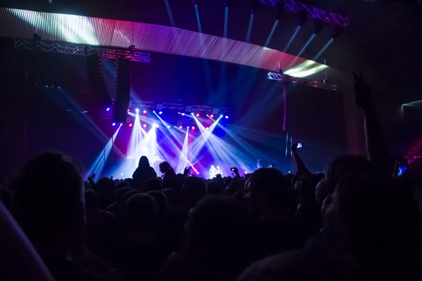 Parlak sahne ışıkları önünde konser kalabalığının siluetleri — Stok fotoğraf