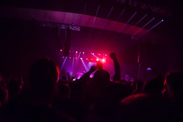 Siluetas de la multitud de conciertos frente a luces de escenario brillantes — Foto de Stock