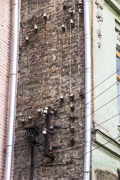 Παλιά καλώδια ηλεκτρικών καλωδίων σε μια γωνιά της οροφής με τα παλιά σπίτια σε μια επικίνδυνη αρχιτεκτονική σκηνή. — Φωτογραφία Αρχείου