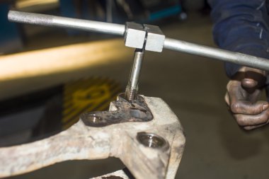 Otomobil tamircisinde çalışan bir tamirci.