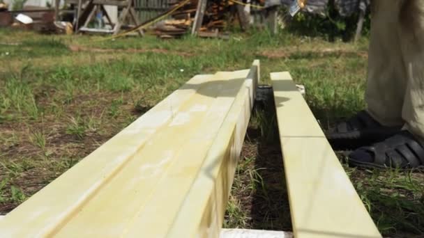 Wood varnish treatment in the summer. a man builds a house — Stock Video