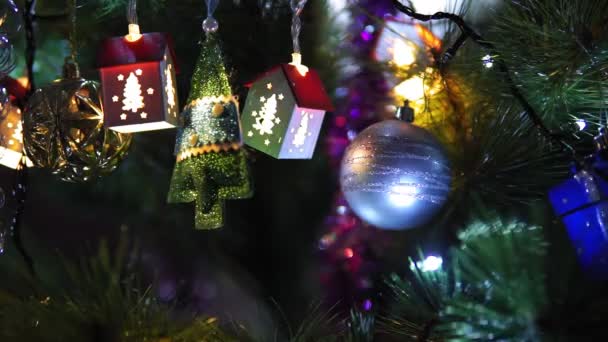 Bola de decoración de Navidad en un árbol de Navidad con guirnaldas parpadeantes. fondo, enfoque selectivo — Vídeos de Stock