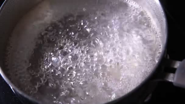 Yemek pişirme. Mutfaktaki tencerede kaynar su. Yavaş çekim seçici odak — Stok video