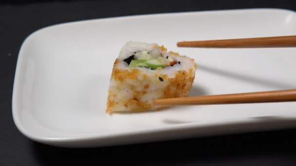 Petits pains et sushis dans un restaurant chinois ou japonais. baguettes en bois — Video