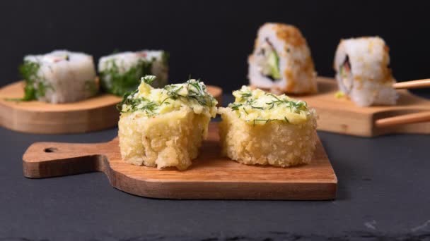 Pães assados e sushi em um restaurante chinês ou japonês. pauzinhos de madeira — Vídeo de Stock