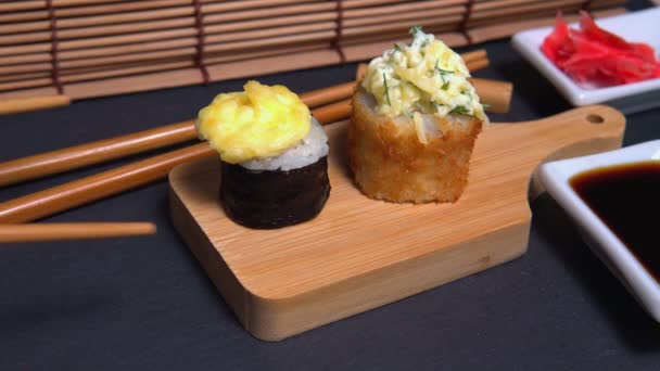 Sushi broodjes met eetstokjes close-up. Maki roll met gebakken saus — Stockvideo