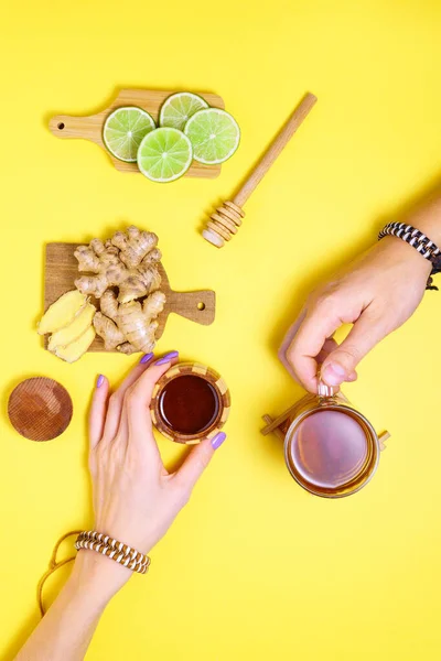 Lime ginger Honey Cup of Herbal Tea. Alternative cold and flu remedy. Healthy Food. on yellow background. Flat Lay. vertical photo