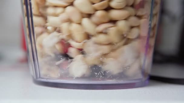 自宅でピーナッツペーストを調理ミキサーでピーナッツ.スローモーションの選択的フォーカス — ストック動画