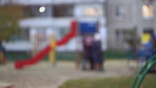 Niños juegan en el parque infantil en el tobogán. fondo borroso — Vídeo de stock