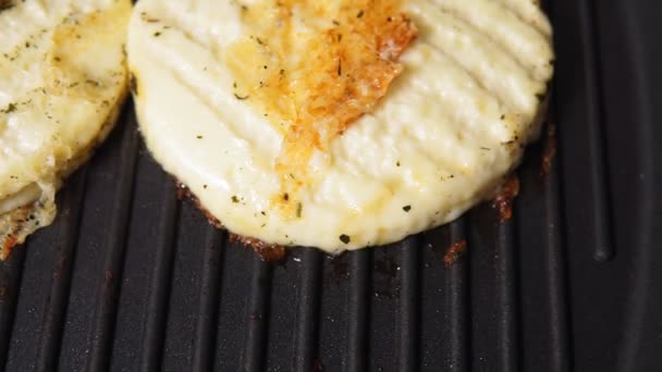 Grilled haloumi cheese with herbs on a grill pan. selective focus — Stock Video