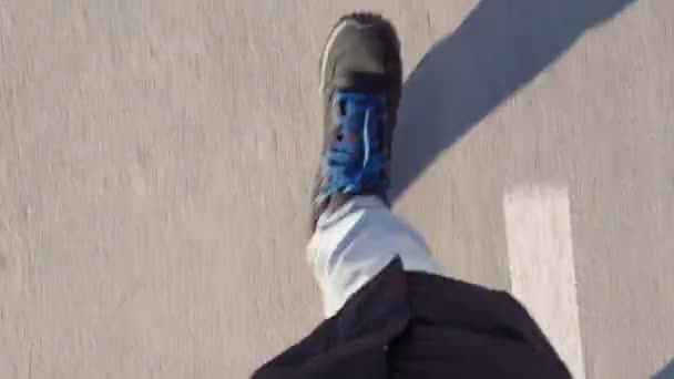 Fötter av en man i vinterstövlar kör på asfalt i vinter pov video — Stockvideo