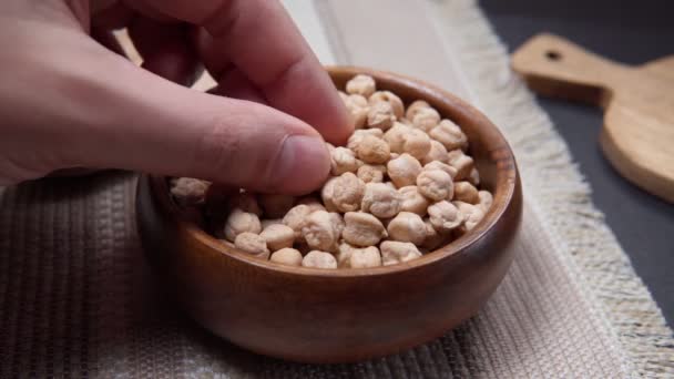 Chickpeas in a wooden bowl on kitchen table. Raw chickpeas close-up — Stock Video