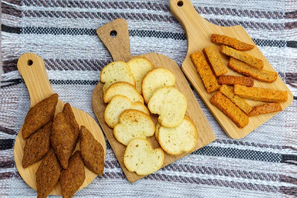 Different types croutons on wooden boards close-up, white, brown, dark — Stock Image Different Types Croutons Wooden Boards Close White Brown Dark Stock Photo