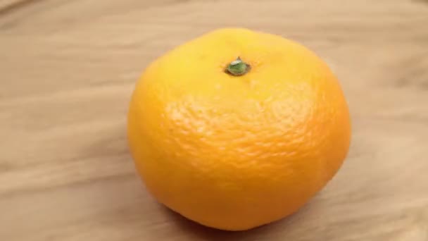 Fruta de mandarina cerca girando sobre un fondo de madera — Vídeo de stock