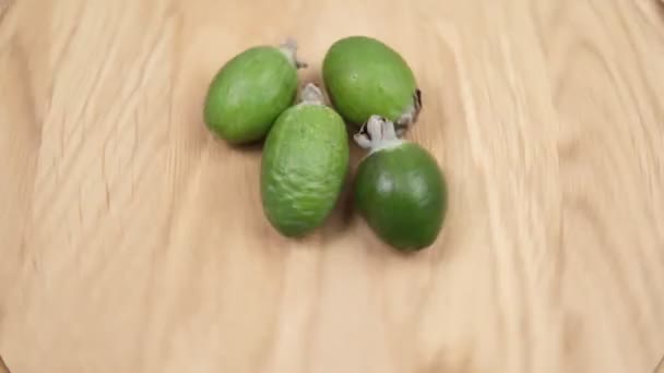 Фейхоа фрукти крупним планом обертається на дерев'яному фоні — стокове відео