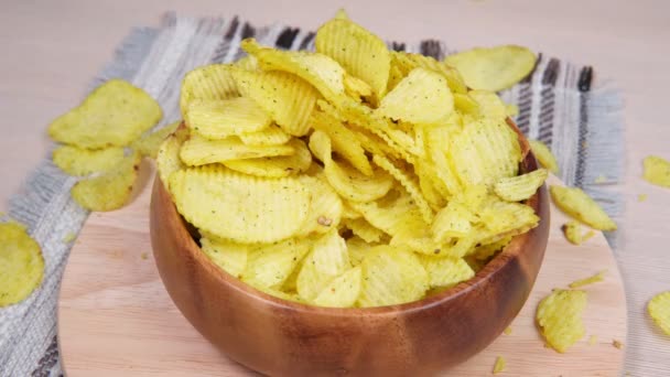 Potato fluted chips are eaten with your hands from a bowl — Stock Video
