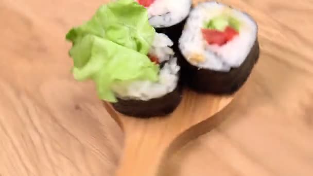 Los rollos veganos de sushi con aguacate, ensalada de pepino y tomate rotan. Concepto de comida vegana saludable. — Vídeo de stock
