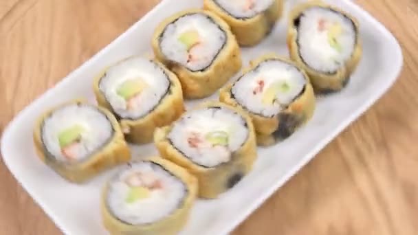 Set baked tempura sushi rolls on wooden table. Rotate. selective focus — Stock Video