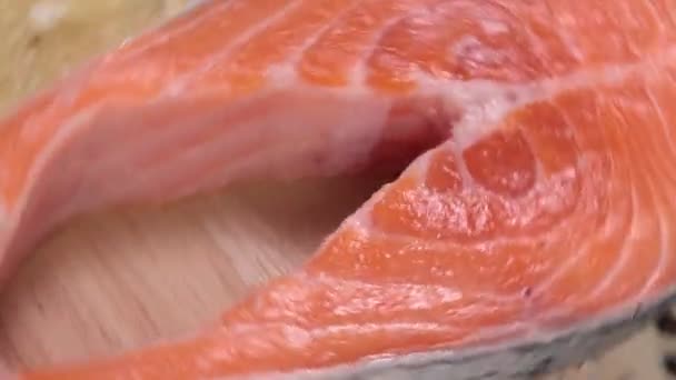Surowy stek łososiowy z bliska - w górę przędzenie na drewnianym tle — Wideo stockowe