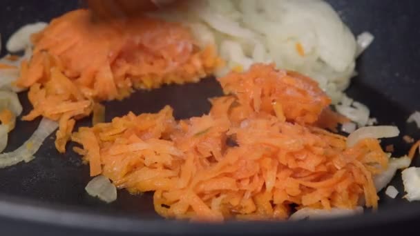 Vaření zmrazené mrkve, smažení v pánvi s cibulí zblízka — Stock video