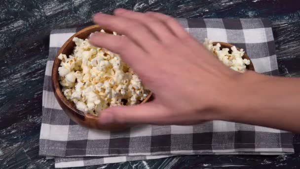 Popcorn in ciotola di legno rotondo su sfondo texture nera, snack notte film — Video Stock