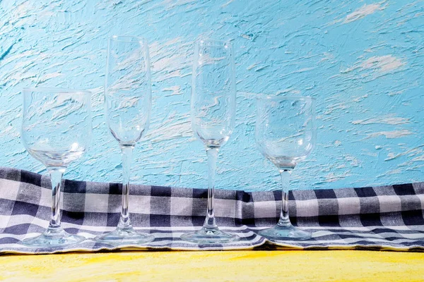 Empty wine glasses, the container for the alcoholic beverage. Yellow blue background.