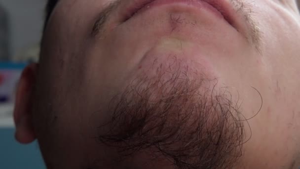 Närbild på en ung skäggig man som rör vid skägget. selektivt fokus — Stockvideo