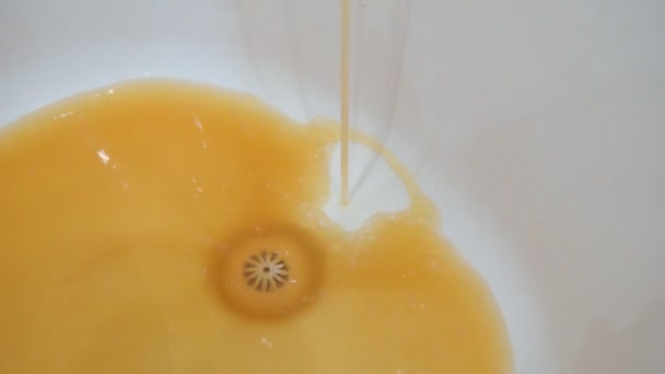 Smutsigt vatten från kranen. Rostigt vatten rinner ut i ett vitt handfat från en kran — Stockvideo