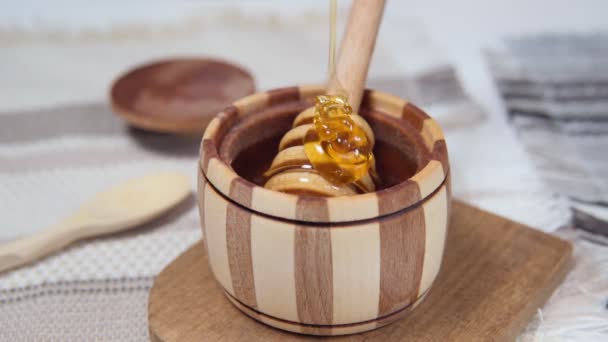 Miele sano organico denso sgocciolante dal cucchiaio di miele di legno, primo piano. Dolce dessert sfondo. — Video Stock