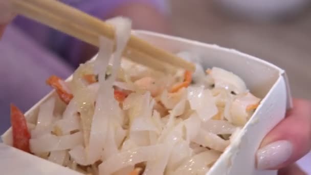 Nouilles dans une boîte close-up. manger des nouilles avec des baguettes à la maison — Video