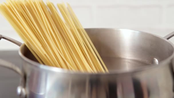 Cozinhar espaguete em uma panela na cozinha para um almoço em casa. foco seletivo — Vídeo de Stock