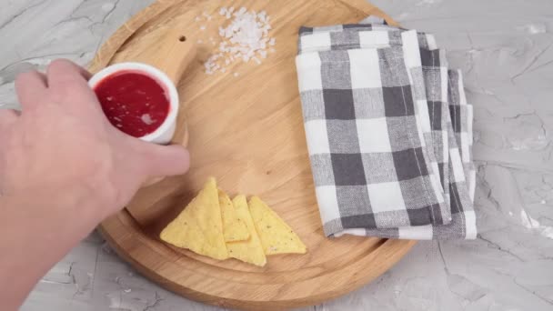 Nachos kukoricaszirom csípős szósszal az asztalon közelről. szelektív fókusz — Stock videók