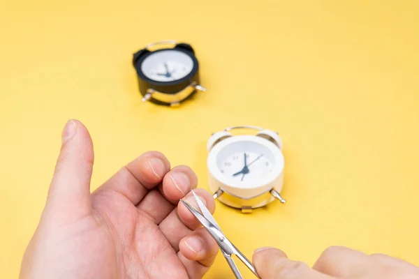 man cuts his nails. yellow background selective focus, copy space