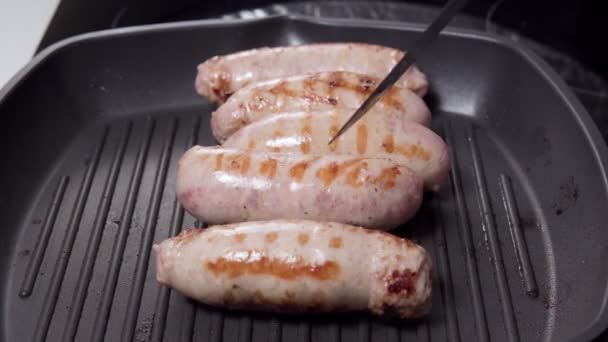 Saucisses grillées juteuses maison sur un foyer sélectif de poêle à griller. Cuisson des aliments — Video