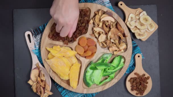Tahta bir tabakta kurumuş meyve manzarası. Mango, elma, kuru erik, kurutulmuş kayısı feijoa. sağlıklı yiyecekler — Stok video