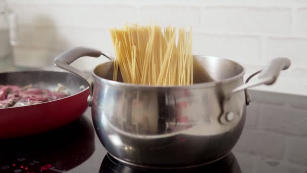 Cocinar espaguetis en una olla para almorzar en casa. enfoque selectivo — Vídeo de stock