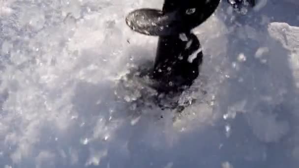 Bohrt Eis mit einer Schnecke aus der Nähe selektiv fokussiert. Winterfischen in Zeitlupe — Stockvideo