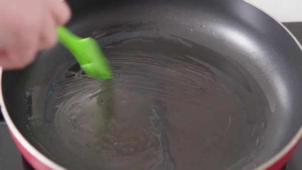 Smelt de pan met olie met een siliconen borstel. kokend voedsel — Stockvideo