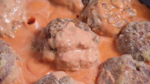 Masové kuličky z mletého vepřového masa smíchaného s mletým hovězím masem pečeným v klasické marinara omáčce. close-up — Stock video