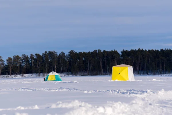 winter tent on the lake for fishing. winter sports space for copying text. fishing equipment