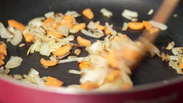 Приготовление моркови и лука на сковороде крупным планом. Вкусная вегетарианская здоровая еда. — стоковое видео