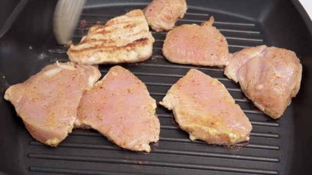 Surowy filet z kurczaka na patelni. gotowanie jedzenia. Kawałki kurczaka — Wideo stockowe