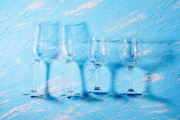 Empty wine glasses, the container for the alcoholic beverage. blue background.