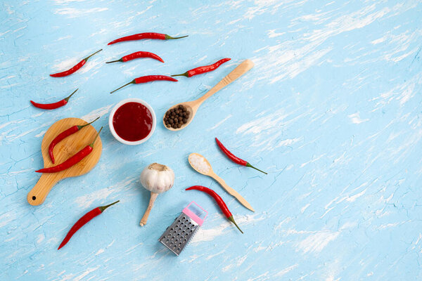 Ингредиенты для соуса чили, перец чили, чеснок, морская соль. вид сверху на голубом фоне