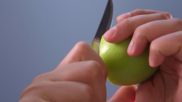 Chef cutting a green apple in half with a large knife. selective focus — Stock Video